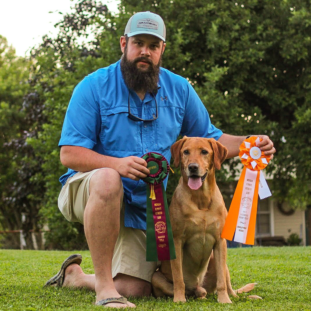 Ian with a trained retriever and hunt test ribbons